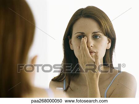 Woman applying moisturizer in mirror View Large Photo Image Stock Image - Woman applying moisturizer in mirror. Fotosearch