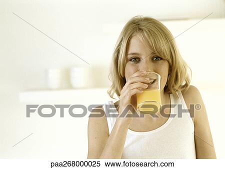 Woman drinking orange juice, head and shoulders View Large Photo Image Stock Photography - Woman drinking orange juice, head and shoulders. Fotosearch