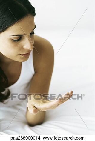 Woman looking at nails on bed View Large Photo Image Picture - Woman looking at nails on bed. Fotosearch
