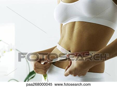 Woman measuring waist, mid section View Large Photo Image Stock Photography - Woman measuring waist, mid section. Fotosearch