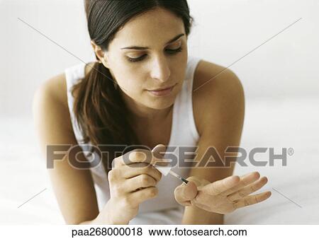 Woman polishing nails on bed View Large Photo Image Stock Photo - Woman polishing nails on bed. Fotosearch