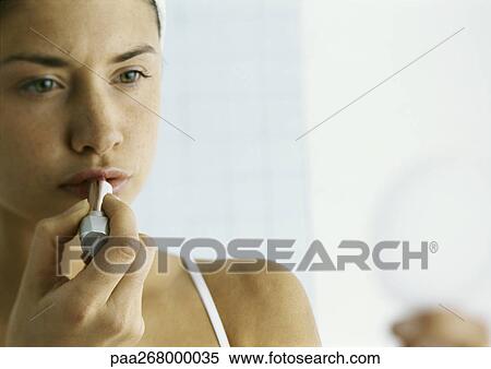 Young woman applying lipstick, close-up View Large Photo Image Stock Photography - Young woman applying lipstick, close-up . Fotosearch