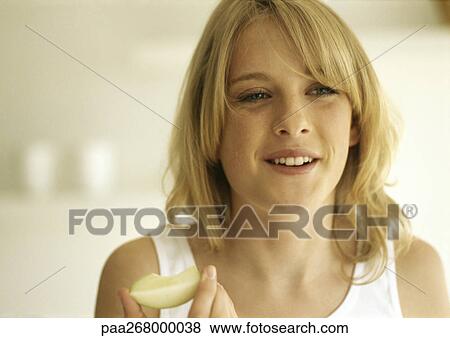 Young woman eating apple slice View Large Photo Image Stock Photo - Young woman eating apple slice. Fotosearch
