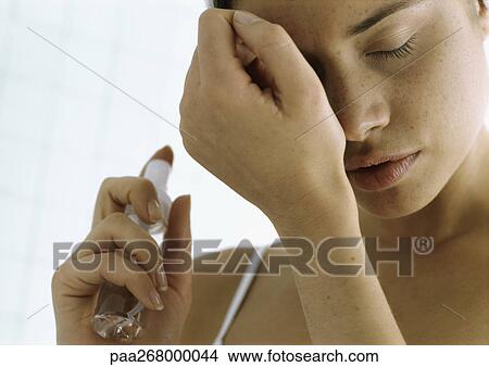 Young woman holding perfume bottle smelling wrist, close-up View Large Photo Image Picture - Young woman holding perfume bottle smelling wrist, close-up. Fotosearch