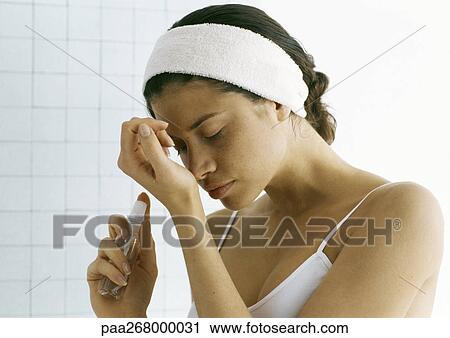 Young woman holding perfume bottle, smelling wrist View Large Photo Image Stock Image - Young woman holding perfume bottle, smelling wrist. Fotosearch