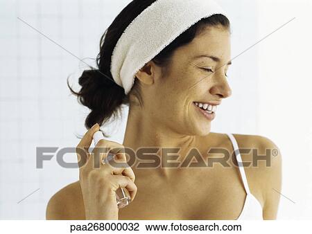Young woman spraying neck with perfume from perfume bottle View Large Photo Image Stock Image - Young woman spraying neck with perfume from perfume bottle. Fotosearch