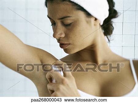 Young woman spraying underarm, head and shoulders View Large Photo Image Stock Image - Young woman spraying underarm, head and shoulders. Fotosearch