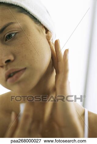 Stock Photo - Young woman touching bare neck, looking away. Fotosearch