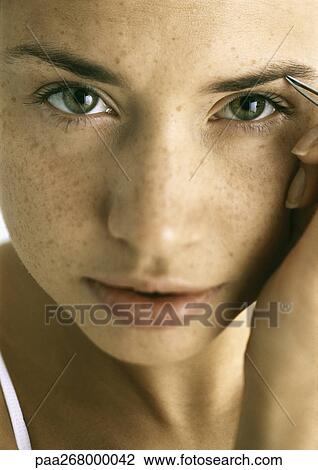 Young woman tweezing eyebrows, close-up View Large Photo Image Stock Image - Young woman tweezing eyebrows, close-up. Fotosearch