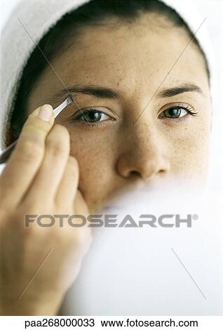 Young woman tweezing eyebrows, compact blurred in foreground View Large Photo Image Stock Image - Young woman tweezing eyebrows, compact blurred in foreground. Fotosearch