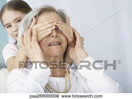 Girl covering grandmother's eyes from behind View Large Photo Image Stock Photo - Girl covering grandmother's eyes from behind. Fotosearch