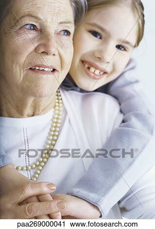 Girl embracing grandmother View Large Photo Image Stock Image - Girl embracing grandmother. Fotosearch