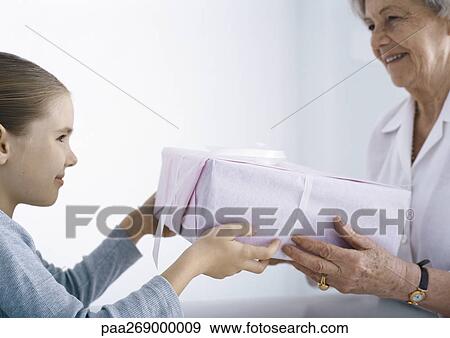 Girl giving package to grandmother View Large Photo Image Stock Photo - Girl giving package to grandmother. Fotosearch