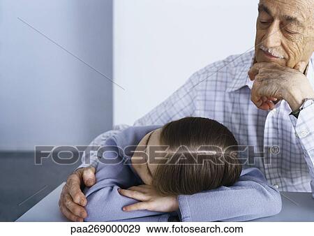 Grandfather and girl sitting at table, girl with head on table View Large Photo Image Stock Photo - Grandfather and girl sitting at table, girl with head on table. Fotosearch