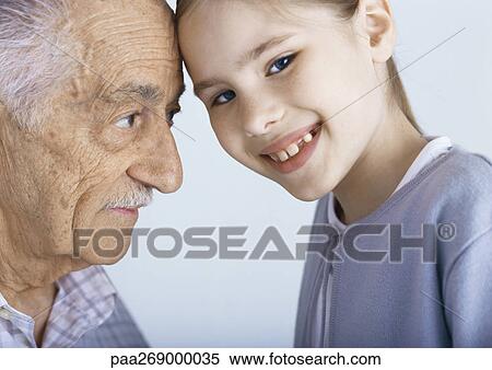 Stock Photography - Grandfather and girl touching foreheads. Fotosearch