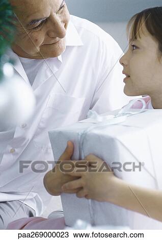 Grandfather looking at girl holding package View Large Photo Image Stock Image - Grandfather looking at girl holding package. Fotosearch