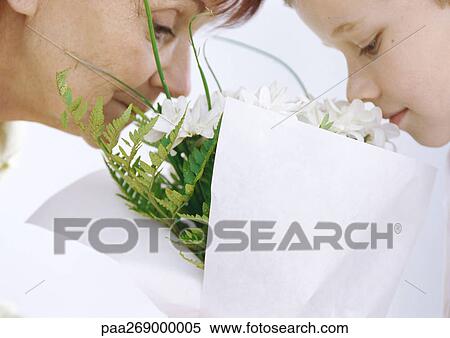 Stock Photography - Grandmother and boy smelling bouquet of flowers. Fotosearch