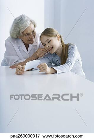Grandmother and girl looking at photo View Large Photo Image Stock Photo - Grandmother and girl looking at photo. Fotosearch
