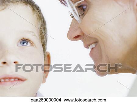 Grandmother whispering into boy's ear View Large Photo Image Picture - Grandmother whispering into boy's ear. Fotosearch
