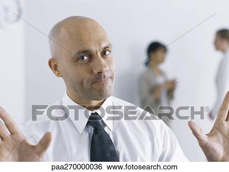 Stock Photograph - Businessman holding up hands, pursing lips. Fotosearch
