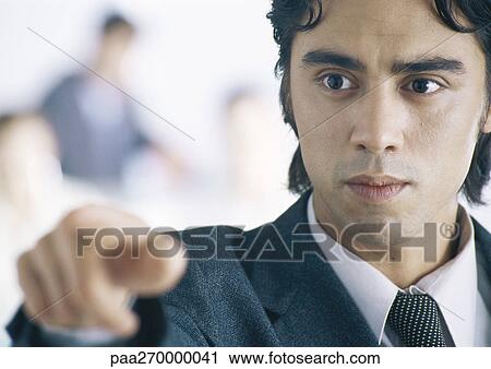 Stock Image - Businessman pointing, close-up. Fotosearch