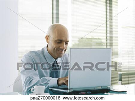Businessman using laptop, smiling View Large Photo Image Stock Photograph - Businessman using laptop, smiling. Fotosearch