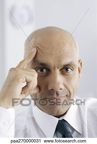 Businessman with fingers on face and forehead, portrait View Large Photo Image Stock Image - Businessman with fingers on face and forehead, portrait. Fotosearch