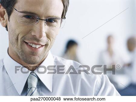 Businessman with glasses, smiling at camera View Large Photo Image Stock Photo - Businessman with glasses, smiling at camera. Fotosearch