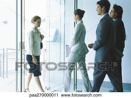 Businesspeople entering and exiting through glass doors View Large Photo Image Stock Image - Businesspeople entering and exiting through glass doors. Fotosearch
