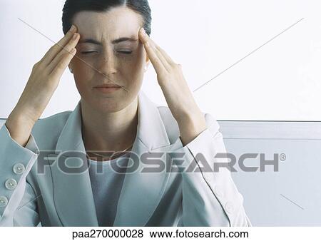 Woman furrowing brow with hands at temples View Large Photo Image Stock Photo - Woman furrowing brow with hands at temples. Fotosearch