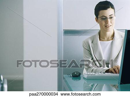 Woman sitting at computer typing View Large Photo Image Picture - Woman sitting at computer typing. Fotosearch