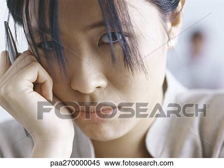 Woman with hand next to face, looking at camera View Large Photo Image Stock Photography - Woman with hand next to face, looking at camera. Fotosearch