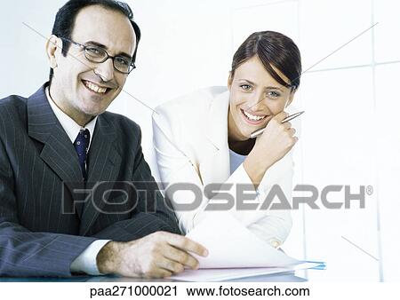 Businessman and businesswoman with documents smiling at camera View Large Photo Image Stock Image - Businessman and businesswoman with documents smiling at camera. Fotosearch