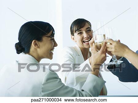 Businesspeople clinking glasses and smiling View Large Photo Image Picture - Businesspeople clinking glasses and smiling. Fotosearch