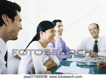 Businesspeople sitting around table together, laughing View Large Photo Image Stock Photo - Businesspeople sitting around table together, laughing. Fotosearch