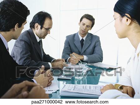 Businesspeople sitting at table having meeting View Large Photo Image Stock Image - Businesspeople sitting at table having meeting. Fotosearch