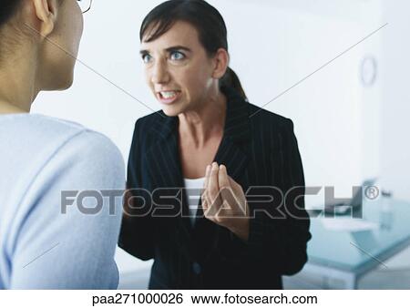 Businesswoman speaking and gesturing angrily to second woman View Large Photo Image Stock Photograph - Businesswoman speaking and gesturing angrily to second woman. Fotosearch