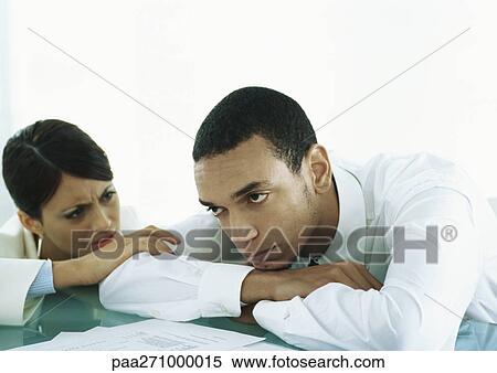 Man with head down on table, women touching his arm looking at him with concern View Large Photo Image Stock Photography - Man with head down on table, women touching his arm looking at him with concern. Fotosearch