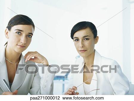 Two businesswomen looking at camera, head and shoulders View Large Photo Image Stock Image - Two businesswomen looking at camera, head and shoulders. Fotosearch