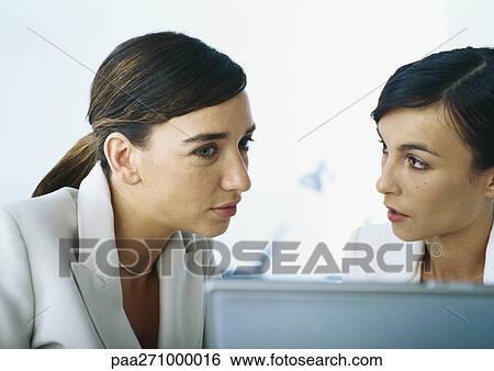 Two businesswomen speaking together, head and shoulders View Large Photo Image Stock Photograph - Two businesswomen speaking together, head and shoulders. Fotosearch