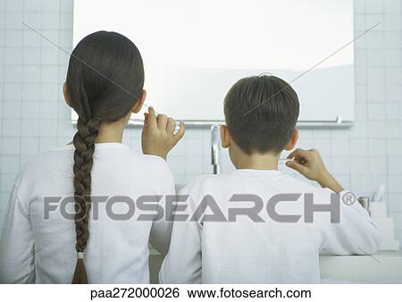 Boy and girl brushing teeth, rear view View Large Photo Image Stock Photograph - Boy and girl brushing teeth, rear view. Fotosearch
