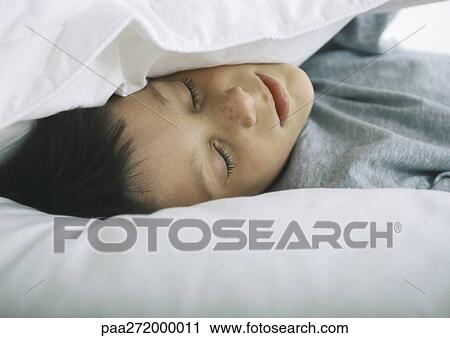Boy lying with head in pillows View Large Photo Image Stock Image - Boy lying with head in pillows. Fotosearch