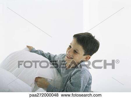 Boy smiling, holding pillow View Large Photo Image Stock Photo - Boy smiling, holding pillow. Fotosearch