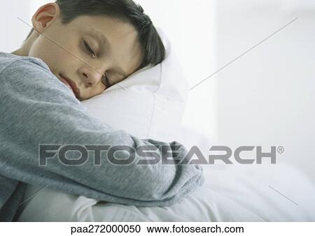 Boy with eyes closed snuggling with pillow View Large Photo Image Stock Image - Boy with eyes closed snuggling with pillow. Fotosearch