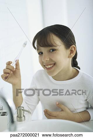 Girl holding up toothbrush View Large Photo Image Stock Image - Girl holding up toothbrush. Fotosearch