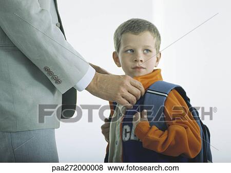 Man buttoning coat of boy with backpack View Large Photo Image Stock Photo - Man buttoning coat of boy with backpack. Fotosearch