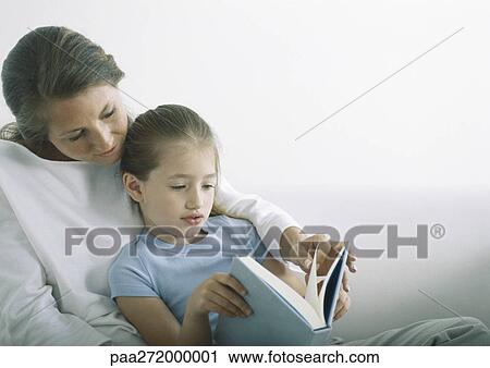 Woman and girl reading book together View Large Photo Image Stock Image - Woman and girl reading book together. Fotosearch