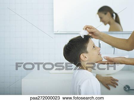 Woman combing boy's hair View Large Photo Image Stock Image - Woman combing boy's hair. Fotosearch