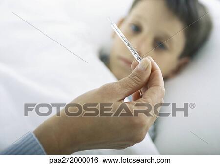 Woman's hand holding thermometer, boy in bed View Large Photo Image Stock Photograph - Woman's hand holding thermometer, boy in bed. Fotosearch