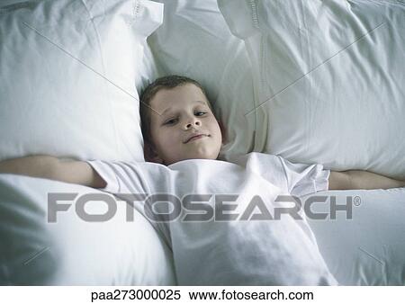 Boy lying on bed with arms out View Large Photo Image Stock Photography - Boy lying on bed with arms out. Fotosearch